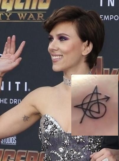 A picture of Avengers logo tattoo on the biceps of Scarlett.